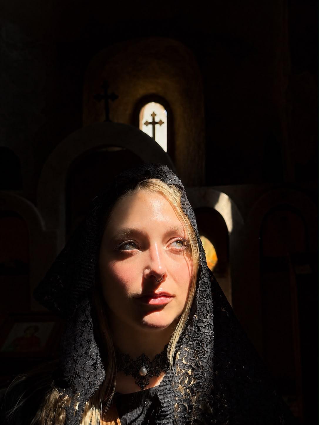 Nicky in a black lace headscarf, her face lit by sunlight